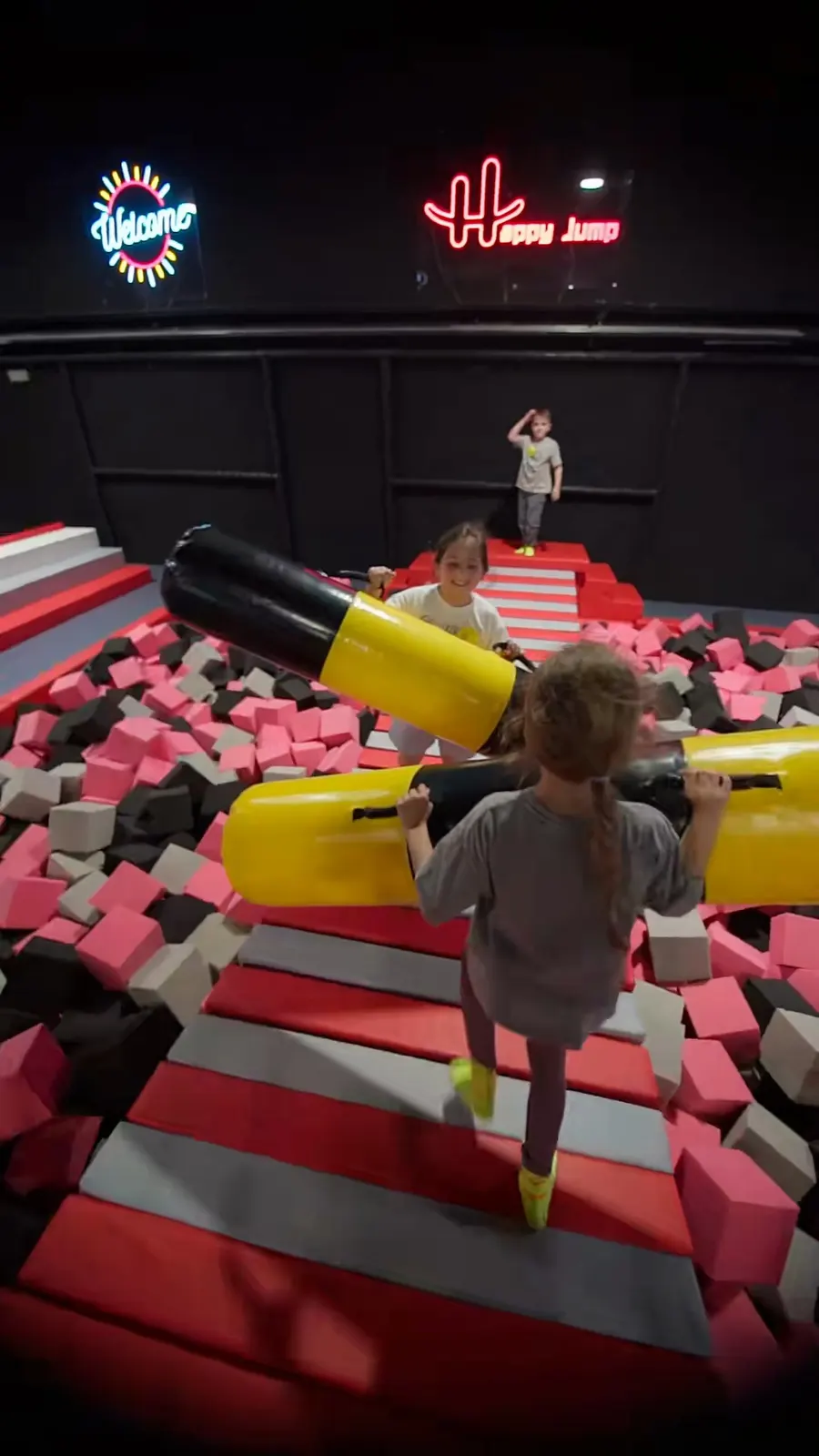 Dos niños con mazas hinchables sobre la pasarela del foso